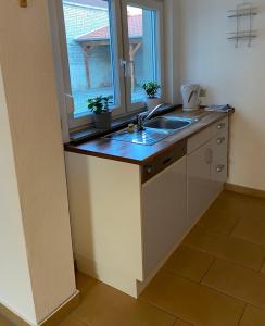 uma cozinha com um lavatório e uma janela em Großzügige Wohnung mit Schreibtischarbeitsplatz in Genthin OT Tucheim em Tucheim
