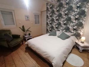 a bedroom with a white bed with a floral wallpaper at Château de bonneville Picardie in Bonneville
