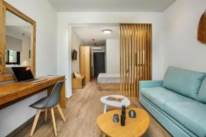 a living room with a blue couch and a table at AlexMare Hotel Fourka in Skala Fourkas
