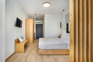 a small bedroom with a bed and a television at AlexMare Hotel Fourka in Skala Fourkas