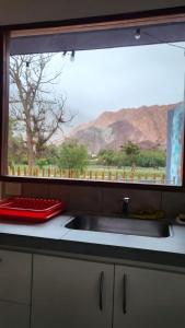 a kitchen counter with a sink and a window at Imagine duplex in Purmamarca
