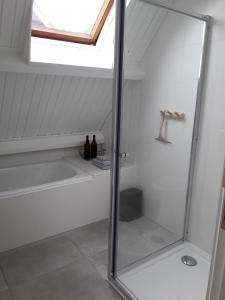 a bathroom with a shower and a bath tub with a window at Natuurhuisje Wolterholten in Baars