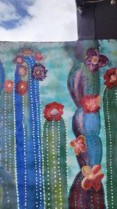 a painting of cacti and flowers on a wall at Imagine duplex in Purmamarca