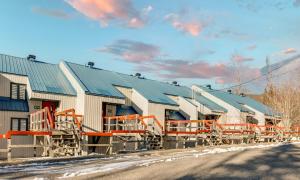 ein großes Gebäude mit orangefarbenen Schienen neben einer Straße in der Unterkunft Le Cozy-Condo à louer à Stoneham (CITQ 239956) in Stoneham