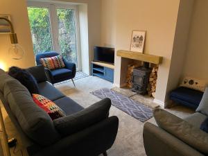 a living room with a couch and a fireplace at 4 bedroom coastal cottage with walled garden in Embleton