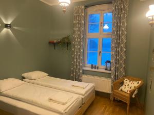 a bedroom with a bed and a window and a chair at Leśniczówka Szeroki Bór in Szeroki Bór