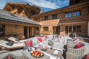 an outdoor patio with tables and chairs on a building at Grand Chalet de Rougemont in Rougemont