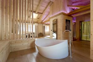 a large bathroom with a tub and wooden walls at Grand Chalet de Rougemont in Rougemont +51 photos