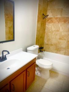 uma casa de banho com um lavatório, um WC e uma banheira em ShutEye Hostel em Houston