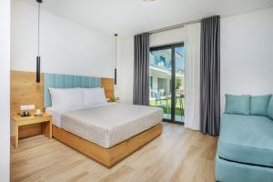 a bedroom with a bed and a blue couch at AlexMare Hotel Fourka in Skala Fourkas