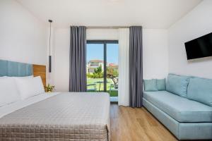 a hotel room with a bed and a couch at AlexMare Hotel Fourka in Skala Fourkas