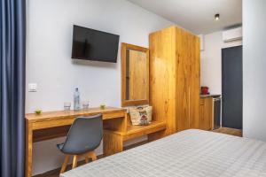 a bedroom with a desk and a chair and a television at AlexMare Hotel Fourka in Skala Fourkas