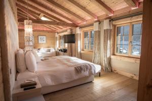 a bedroom with a large white bed and windows at Grand Chalet de Rougemont in Rougemont