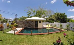 a swimming pool in the yard of a house at Villa des Frangipanes in La Gaulette