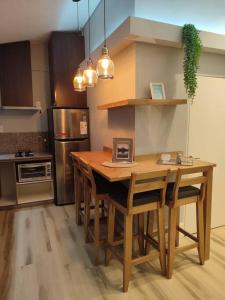 cocina con mesa de madera con sillas y nevera en Departamento Céntrico y Moderno en Posadas