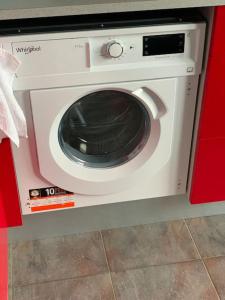 a washing machine is sitting in a red cabinet at Quiet and comfortable apartment with parking for a nice stay for one,two or a couple with a child in Tallinn