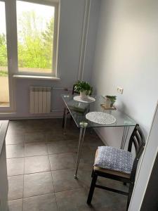 a glass table and a chair in a room with a window at Quiet and comfortable apartment with parking for a nice stay for one,two or a couple with a child in Tallinn