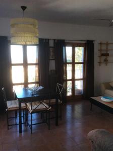 sala de estar con mesa, sillas y ventanas en Apartment Mojacar Pueblo Rentals, en Mojácar
