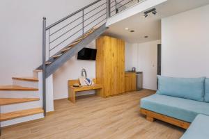 a living room with a blue couch and stairs at AlexMare Hotel Fourka in Skala Fourkas