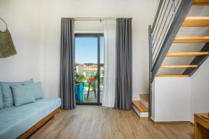 a living room with a couch and a staircase at AlexMare Hotel Fourka in Skala Fourkas