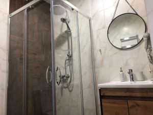 W łazience znajduje się prysznic, umywalka i lustro. w obiekcie Panorama w Sławsku