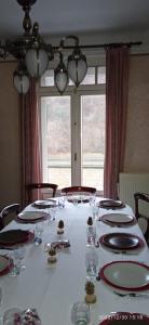een lange tafel met borden en glazen en een raam bij Echappée mosane in Waulsort