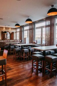 a large room with tables and chairs and windows at Hotel Bolte in Salzbergen