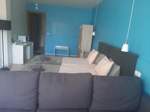 un grande letto con un divano in una camera di Quartos do Seixe - Azul a Odeceixe