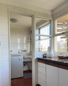 a kitchen with a white refrigerator and a window at Bitcoins House Costanera in Corrientes