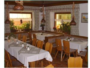 Gasthof Sölln في لام: غرفة طعام مع طاولات وكراسي بيضاء