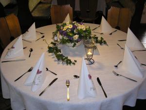 einen Tisch mit einem weißen Tischtuch und Blumen darauf in der Unterkunft Gasthof Sölln in Lam