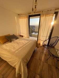 1 dormitorio con cama grande y ventana grande en Altos del Espinillo - Casa de Montaña in 