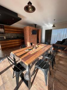 una gran mesa de madera con sillas en una habitación en Altos del Espinillo - Casa de Montaña in 