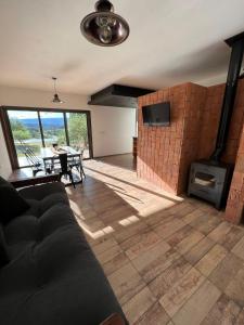sala de estar con sofá y chimenea en Altos del Espinillo - Casa de Montaña in 