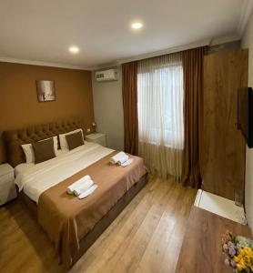 a bedroom with a large bed with towels on it at Book Hotel in Tbilisi City