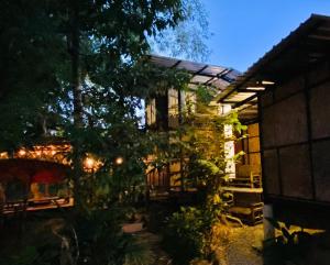 uma casa com um quintal iluminado à noite em แม่ไพโฮมสเตย์ ล่องแพกอนโดล่า 