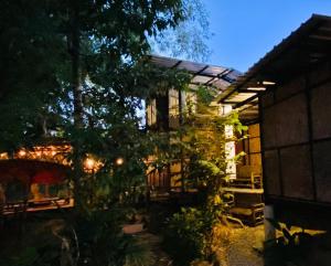 a house with a lit up backyard at night at แม่ไพโฮมสเตย์ ล่องแพกอนโดล่า in Ban Racha Tai