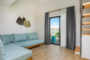 a living room with a couch and a large window at AlexMare Hotel Fourka in Skala Fourkas