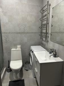 a bathroom with a white toilet and a sink at APARTMENT ON CENTRE LVIV in Lviv