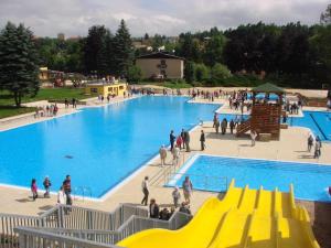 a large swimming pool with people walking around it at Chalupa u golfu Kořenec in Kořenec