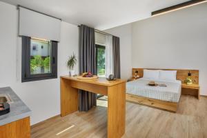 a bedroom with a bed and a table with a bowl of fruit on it at AlexMare Hotel Fourka in Skala Fourkas