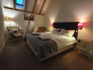 a bedroom with a large bed and a chair at B&B Joostink in Vorden in Vorden