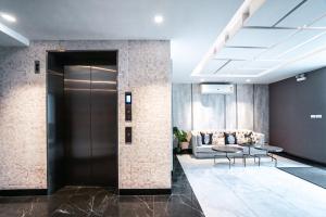 a lobby with a door and a couch at I'm Chinatown Residence in Bangkok