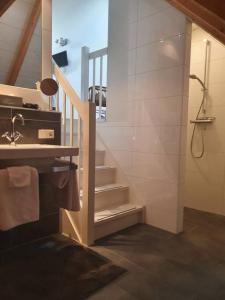 a bathroom with a staircase and a shower and a sink at B&B Joostink in Vorden in Vorden