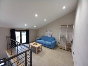 un soggiorno con divano blu e tavolo di Villa Lavanda a Lequio Tanaro