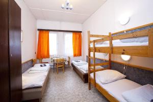 a room with three bunk beds and a table at Hotel Sklárna Harrachov in Harrachov