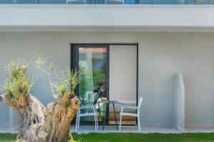 a door leading to a patio with a table and chairs at AlexMare Hotel Fourka in Skala Fourkas