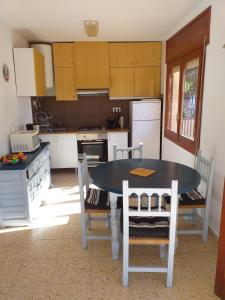 a kitchen with a table and chairs and a kitchen with white appliances at El nispero in Peniscola