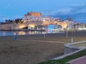 a view of a beach at night with buildings at El nispero in Peniscola +4 photos