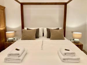 法塔加Casa Rural Palomar - Men Only的卧室里有一张白色的大床，床上放着毛巾